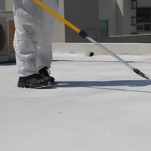 a worker applying a roof coating