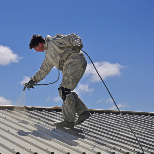 coating being applied to a metal roof